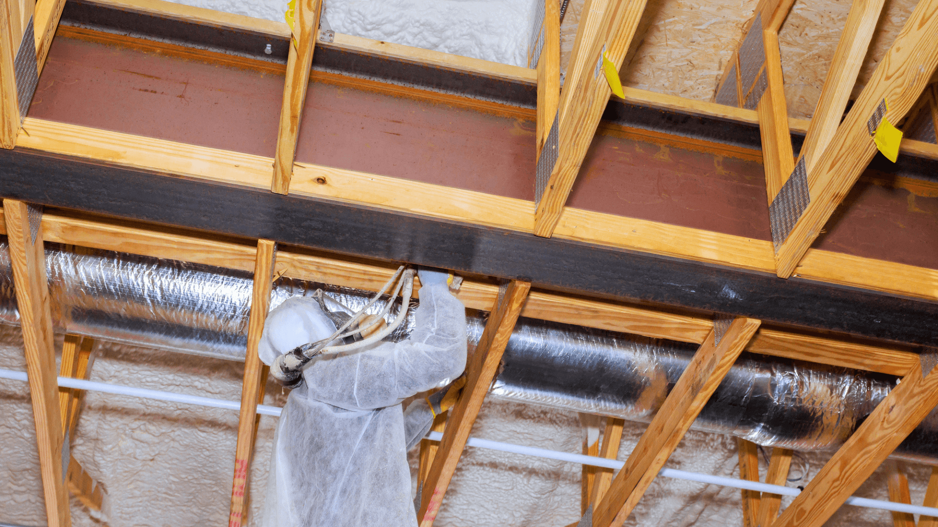 Construction worker installs spray foam insulation in a Southfield, MI home
