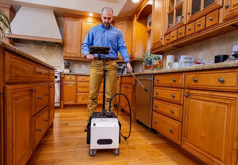 Man performing indoor air quality and mold testing in a kitchen in Novi, MI